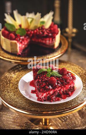 Tranche de cheesecake à la sauce aux baies rouges et décorée avec de la menthe verte Banque D'Images