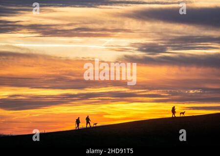 Ciel rouge soir, coucher de soleil, vue de Mottbruch Halde à Gladbeck, à l'ouest, marcheurs avec chiens, NRW, Allemagne, Banque D'Images