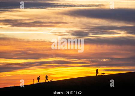 Ciel rouge soir, coucher de soleil, vue de Mottbruch Halde à Gladbeck, à l'ouest, marcheurs avec chiens, NRW, Allemagne, Banque D'Images