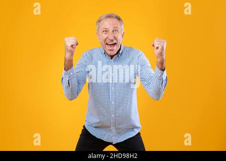 Portrait d'un homme mûr excité criant avec des poings relevés Banque D'Images