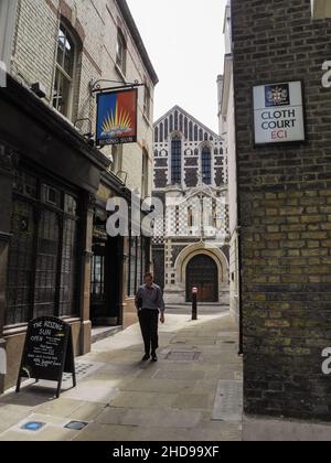 Un homme passant devant la maison publique Rising Sun sur Cloth Fair, Smithfield, Londres, EC1, Angleterre,ROYAUME-UNI Banque D'Images