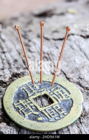 Aiguilles d'acupuncture sur une ancienne pièce de bronze chinoise Banque D'Images