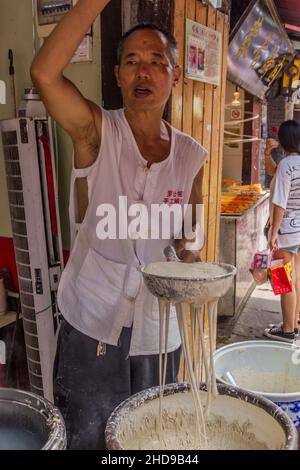 CHONGQING, CHINE - 17 AOÛT 2018 : fabricant de nouilles dans la vieille ville de Ciqikou, Chine Banque D'Images