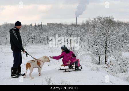 Kramatorsk, Ukraine.26th décembre 2021.Une jeune fille a vu jouer avec un chien avant de traîneaux.La luge est un vieux divertissement d'hiver en Ukraine.(Photo par Andriy Andriyenko/SOPA Images/Sipa USA) crédit: SIPA USA/Alay Live News Banque D'Images