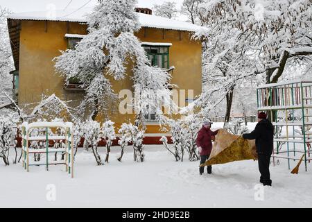 Kramatorsk, Ukraine.26th décembre 2021.On voit des personnes âgées nettoyer la moquette avec de la neige.Le nettoyage de la neige des tapis en plein air est une vieille tradition chez les Ukrainiens.(Photo par Andriy Andriyenko/SOPA Images/Sipa USA) crédit: SIPA USA/Alay Live News Banque D'Images