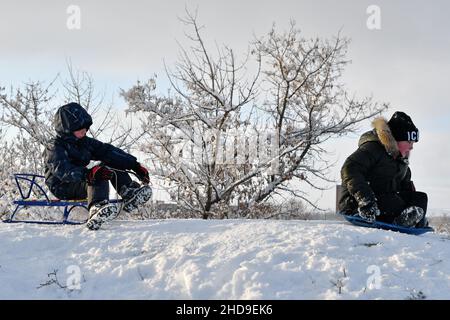 Kramatorsk, Donetsk, Ukraine.26th décembre 2021.Les enfants sont vus traîneaux d'une colline de neige dans un parc de la ville de Kramatorsk.La luge est un vieux divertissement d'hiver en Ukraine.(Credit image: © Andriy Andriyenko/SOPA Images via ZUMA Press Wire) Banque D'Images