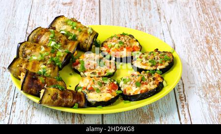 Un en-cas festif d'aubergines cuites sur une belle assiette.Tranches et petits pains de légumes avec une garniture savoureuse. Banque D'Images