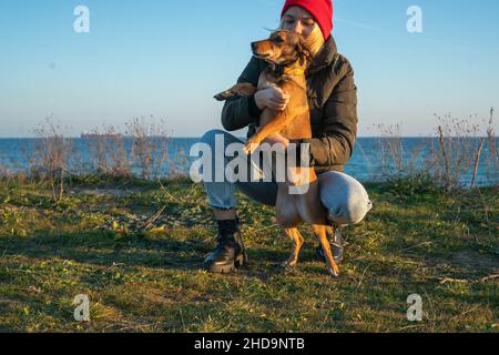 Une fille blonde avec un chien de race pure de l'abri.Jouer avec un chien sur la mer.Amitié d'un chien et d'une personne Banque D'Images