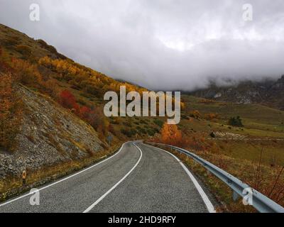 Une vue panoramique d'une route vide menant à des montagnes couvertes de nuages en Italie Banque D'Images