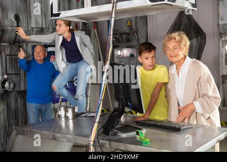 Les grands-parents et les petits-enfants ont résolu les énigmes dans la salle d'évacuation Banque D'Images