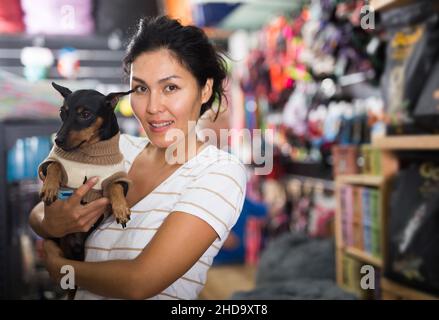 Femme avec zwergpinscher dans la boutique d'animaux Banque D'Images