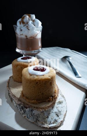 Helsinki / Finlande - 4 JANVIER 2022: Aliments traditionnels finlandais: Gros plan de la torte de Runeberg avec garniture de framboise.Une tasse de chocolat chaud sur le côté. Banque D'Images