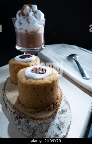 Helsinki / Finlande - 4 JANVIER 2022: Aliments traditionnels finlandais: Gros plan de la torte de Runeberg avec garniture de framboise.Une tasse de chocolat chaud sur le côté. Banque D'Images