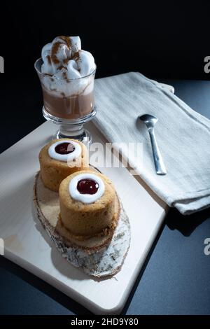 Helsinki / Finlande - 4 JANVIER 2022: Aliments traditionnels finlandais: Gros plan de la torte de Runeberg avec garniture de framboise.Une tasse de chocolat chaud sur le côté. Banque D'Images