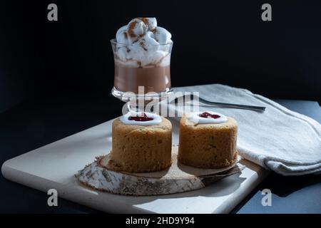 Helsinki / Finlande - 4 JANVIER 2022: Aliments traditionnels finlandais: Gros plan de la torte de Runeberg avec garniture de framboise.Une tasse de chocolat chaud sur le côté. Banque D'Images