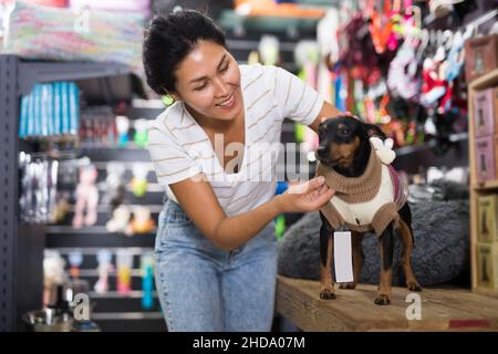 Femme habillant son chien dans la boutique d'animaux Banque D'Images