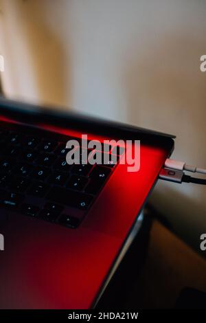 Gros plan du clavier de l'ordinateur portable avec prises de câbles branchées Banque D'Images