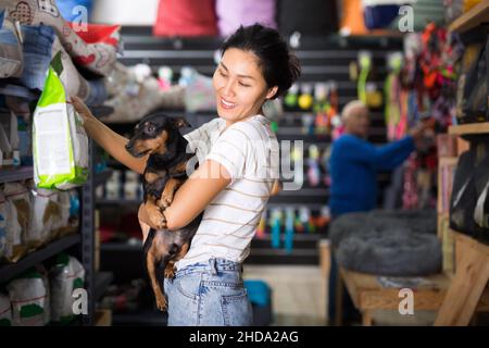 Femme choisissant de la nourriture pour chiens dans la boutique pour animaux Banque D'Images