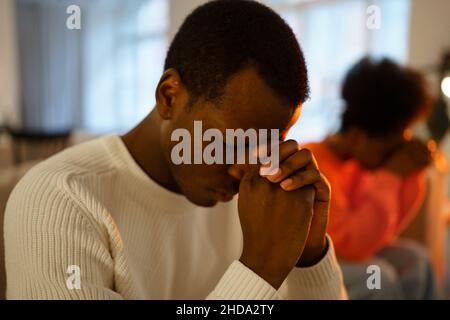 Un homme africain déprimé est assis sur un canapé avec une petite amie et se sent triste et cassé après la pause Banque D'Images