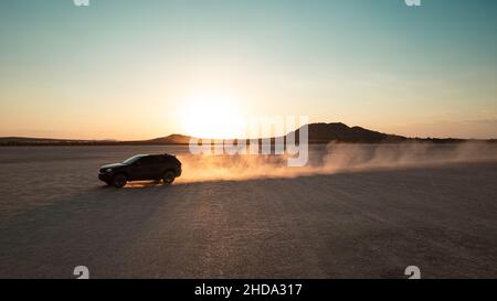 4x4 tout-terrain sur un lac sec au coucher du soleil en été Banque D'Images