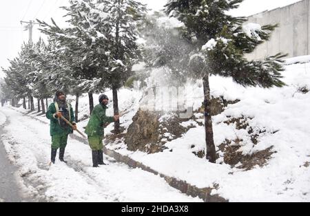 Kaboul, Afghanistan.4th janvier 2022.Des hommes afghans nettoient la neige dans la rue de Kaboul, capitale de l'Afghanistan, le 4 janvier 2022.Credit: Saifurahman Safi/Xinhua/Alamy Live News Banque D'Images