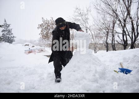 Kaboul, Afghanistan.4th janvier 2022.Un enfant afghan fait un bonhomme de neige à Kaboul, capitale de l'Afghanistan, le 4 janvier 2022.Credit: Saifurahman Safi/Xinhua/Alamy Live News Banque D'Images