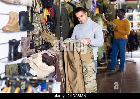 Homme choisissant des vêtements de camouflage Banque D'Images