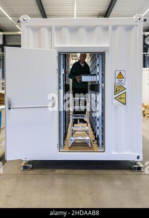 PRODUCTION - 18 novembre 2021, Saxe-Anhalt, Wittenberg: Un employé de Tesvolt GmbH assemble l'APU (unité d'alimentation active) dans un conteneur de 40 pieds, qui est destiné à un système de stockage de 4MWh batteries pour un parc solaire.Tesvolt développe et construit des systèmes de stockage de batterie pour le commerce et l'industrie.Les unités de stockage d'énergie au lithium à base d'oxyde de nickel-manganèse-cobalt peuvent être combinées à toutes les sources d'énergie renouvelables, y compris une centrale thermique et électrique combinée ou une pile à combustible.Selon ses propres informations, la société a déjà réalisé plus de 2200 projets de stockage dans le monde entier.(À dpa Wittenbe Banque D'Images