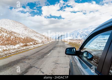 Route asphaltée entre les montagnes par une belle journée d'hiver Banque D'Images