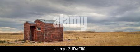 Ancienne cabane en métal rouillé sur une prairie - zone naturelle de Soapstone Prairie dans le nord du Colorado, bannière panoramique Banque D'Images