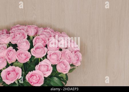 Grand bouquet de roses délicates sur fond de bois clair Banque D'Images