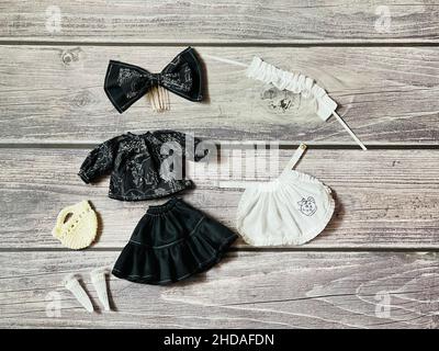 Vue de dessus des costumes de poupée de fille et des accessoires sur une table en bois Banque D'Images