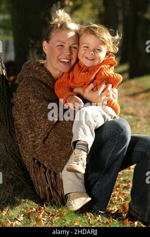 Ein kleiner Junge sitzt mit seiner Mutter im Park Banque D'Images