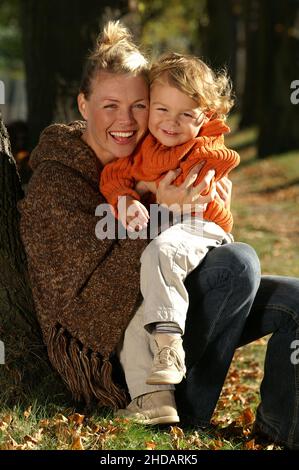 Ein kleiner Junge sitzt mit seiner Mutter im Park Banque D'Images