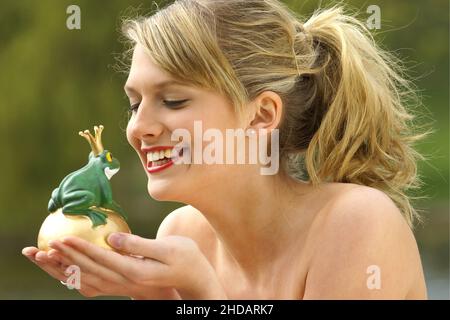 Junge blond Frau küsst einen Frosch mit Krone, Froschkönig, Banque D'Images