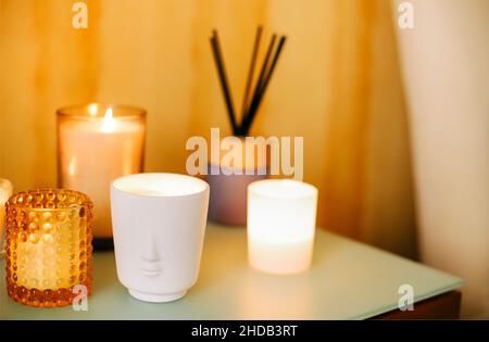 Table avec de nombreux éclairages bougies parfumées et bâtons d'encens aromatiques dans le salon de massage spa ou le studio de yoga, foyer sélectif.Lieu de méditation dans Banque D'Images