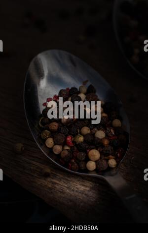 Gros plan de différentes peppercornes de couleur lamées sur un éppon. Banque D'Images