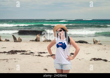 Bonne femme souriante posant pour une photo à côté des lions de mer à Seal Bay, Kangaroo Island, Australie méridionale Banque D'Images