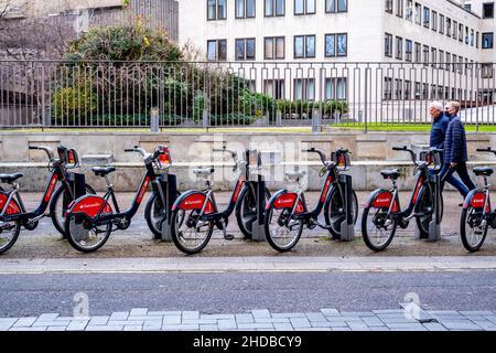 Londres Angleterre Royaume-Uni janvier 02 2022, deux personnes passant devant Une rangée de Santander garés louer vélos Waterloo Londres Banque D'Images