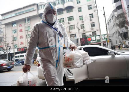 (220105) -- XI'AN, 5 janvier 2022 (Xinhua) -- le volontaire Zhang Bo livre des aliments dans le district de Beilin de Xi'an, dans la province de Shaanxi, dans le nord-ouest de la Chine, 4 janvier 2022.Située dans le district de Yanta à Xi'an, la cuisine commune de Deshan était gérée comme une « cuisine anti-cancer », offrant aux patients atteints de cancer et à leurs familles la commodité de cuisiner des repas.Xu Kai, fondateur de la cuisine commune, a transformé cette « cuisine anti-cancer » en une « cuisine de lutte contre l'épidémie » après que la ville ait été frappée par la récente résurgence de la COVID-19.Jusqu'à présent, plus de 30 bénévoles se sont joints aux activités de livraison de nourriture de la cuisine Banque D'Images