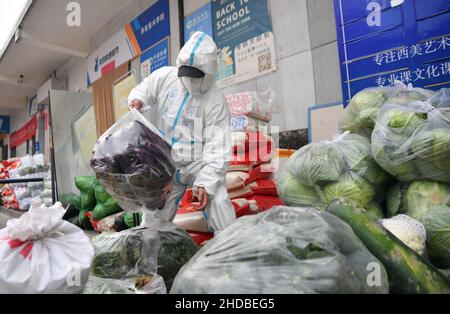 (220105) -- XI'AN, 5 janvier 2022 (Xinhua) -- le volontaire Li Guang porte des légumes à la cuisine partagée de Deshan dans le district de Yanta de Xi'an, dans la province de Shaanxi, dans le nord-ouest de la Chine, 5 janvier 2022.Située dans le district de Yanta à Xi'an, la cuisine commune de Deshan était gérée comme une « cuisine anti-cancer », offrant aux patients atteints de cancer et à leurs familles la commodité de cuisiner des repas.Xu Kai, fondateur de la cuisine commune, a transformé cette « cuisine anti-cancer » en une « cuisine de lutte contre l'épidémie » après que la ville ait été frappée par la récente résurgence de la COVID-19.Jusqu'à présent, plus de 30 bénévoles se sont joints à la livraison des aliments Banque D'Images