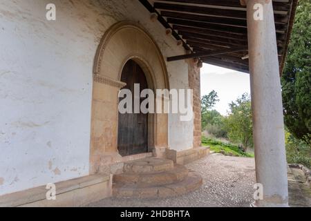 Vue latérale d'un mur de briques et d'une entrée avec une porte en bois avec une arche segmentaire sous l'abri Banque D'Images