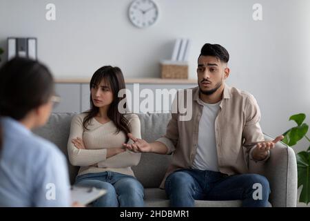 Psychologue féminine donnant une séance de thérapie au couple arabe stressé, les aidant à résoudre les conflits de relations Banque D'Images