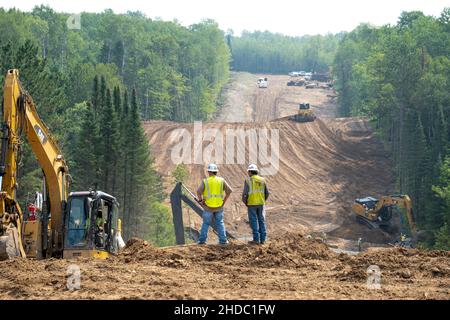 CASS CO, MN - 6 AOÛT 2021 : les travailleurs surplombent le site de construction du gazoduc Enbridge Line 3 dans la forêt du Minnesota avec des excavateurs et du bulldozer.Proje Banque D'Images