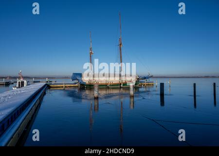 Un voilier dans une marina fermé pour l'hiver.Eau bleue et ciel bleu clair Banque D'Images