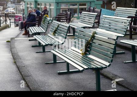 Des grappes de fleurs laissées comme monuments commémoratifs sur des bancs surplombant le port de Scarborough Banque D'Images