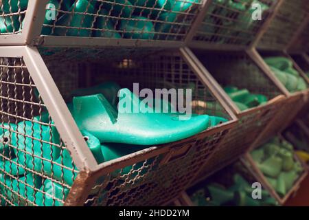 Gros plan de chaussures en plastique dure dans un conteneur à l'usine de fabrication de chaussures Banque D'Images