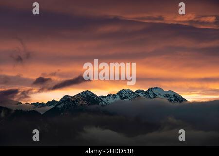 après-midi sombre au coucher du soleil sur les montagnes des alpes autrichiennes enveloppées de brouillard en automne Banque D'Images