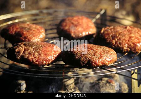 Austin Texas USA, 1996: Viandes haburger de boeuf cru sur une grille de cuisson au charbon de bois pendant la cuisson.©Bob Daemmrich Banque D'Images