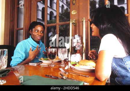 Austin Texas USA, 1993: Une jeune fille hispanique de l'adolescence (à droite) et une jeune femme noire ont dîné ensemble au restaurant.©Bob Daemmrich Banque D'Images